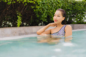 Portrait beautiful young asian woman relax smile around outdoor swimming pool for leisure and vacation